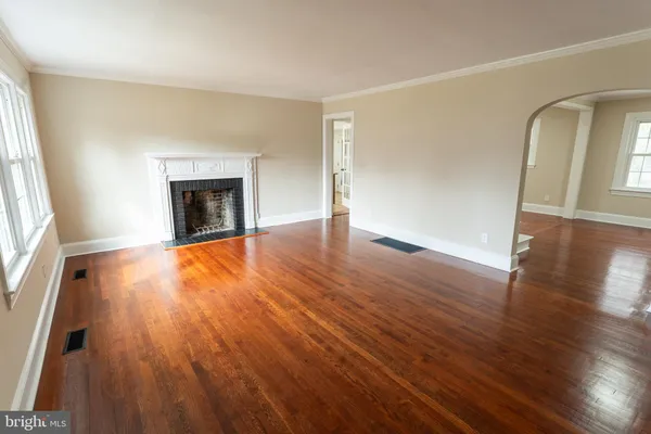 an empty room with wooden floor and fireplace