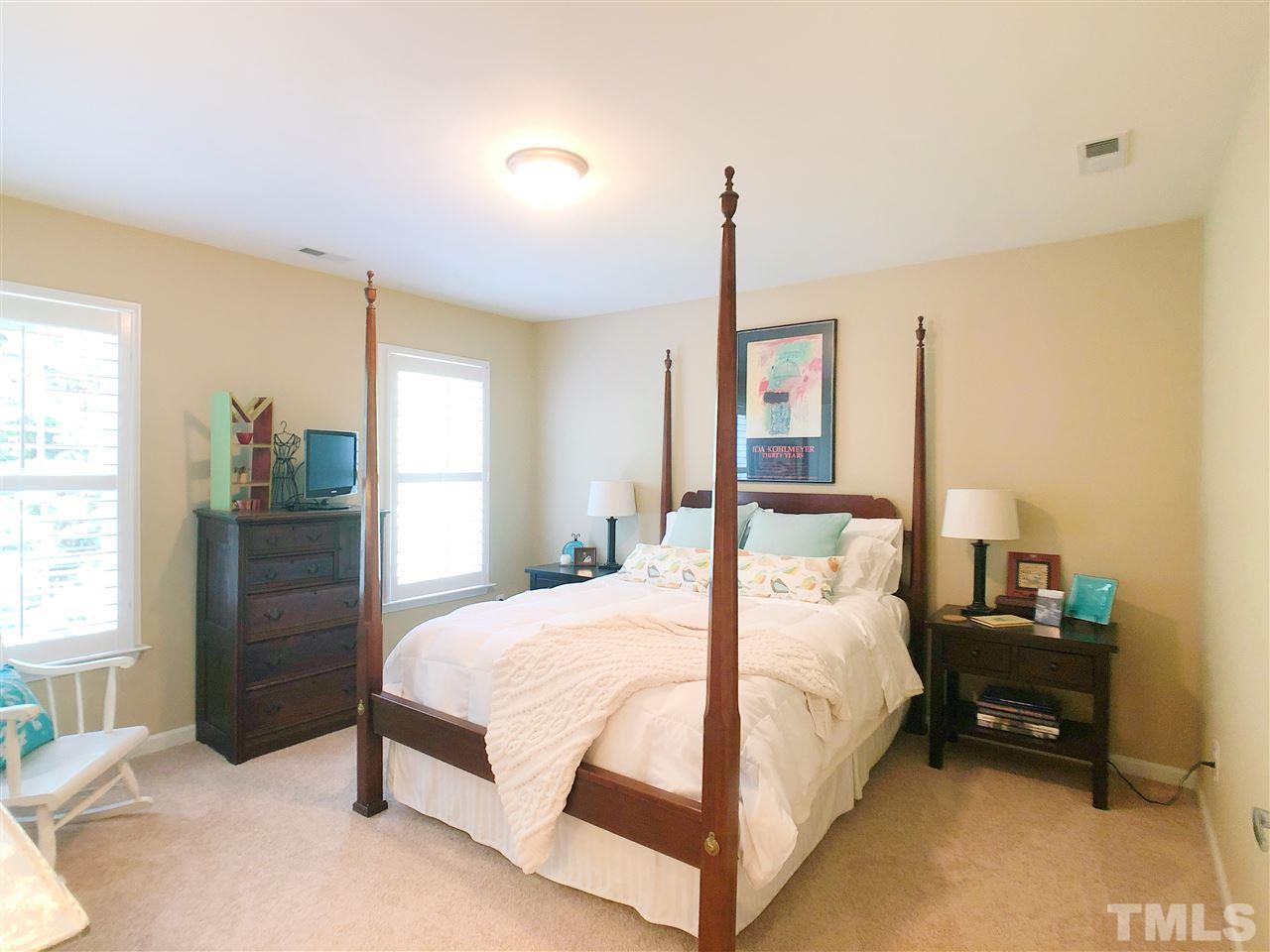 3927 Sunset Maple Court Raleigh, NC 27612 - Photo 14 of 18 a bedroom with a bed and large window