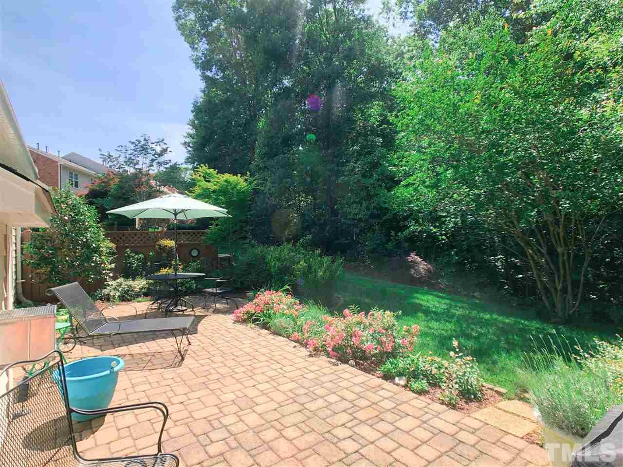 3927 Sunset Maple Court Raleigh, NC 27612 - Photo 18 of 18 a backyard of a house with a garden and outdoor seating