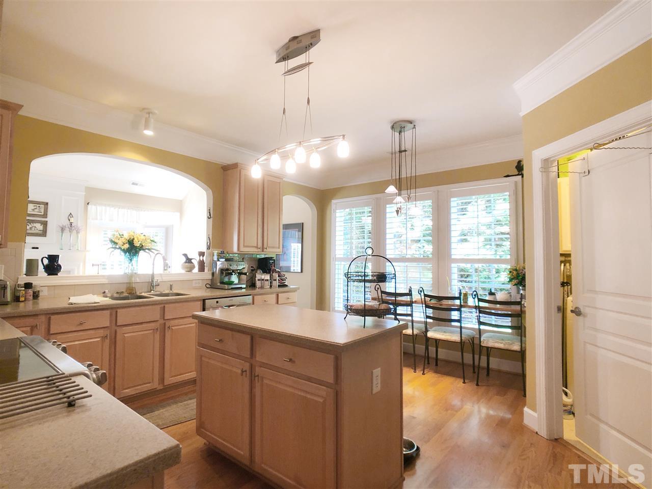 3927 Sunset Maple Court Raleigh, NC 27612 - Photo 4 of 18 a open kitchen with sink cabinets and dining table