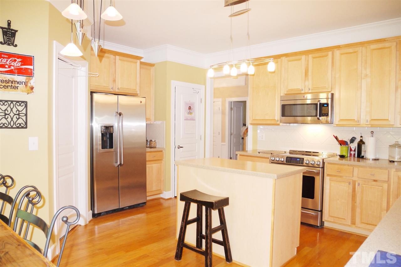 3927 Sunset Maple Court Raleigh, NC 27612 - Photo 5 of 18 a kitchen with stainless steel appliances granite countertop a refrigerator a stove and a sink with wooden floor