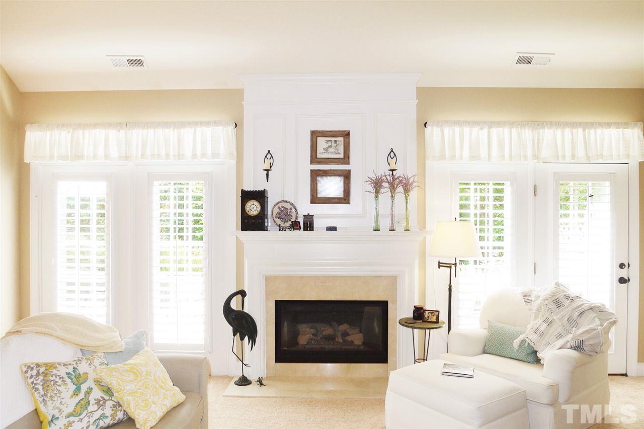 3927 Sunset Maple Court Raleigh, NC 27612 - Photo 6 of 18 a living room with furniture a fireplace and a large window