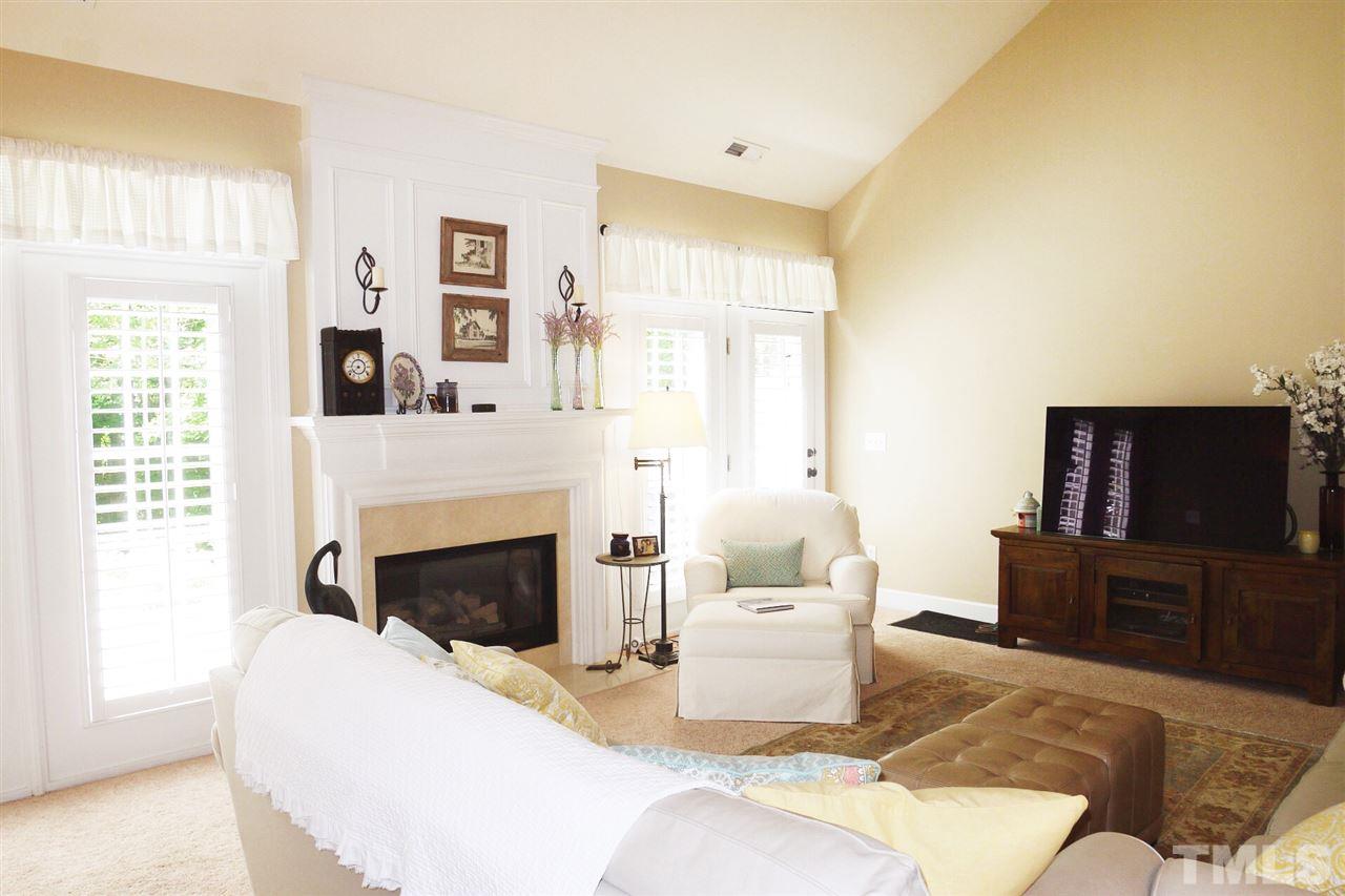 3927 Sunset Maple Court Raleigh, NC 27612 - Photo 7 of 18 a living room with furniture a flat screen tv and a fireplace
