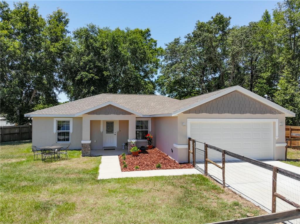6734 Cherry Road Ocala, FL 34472 - Photo 1 of 1 a front view of a house with a yard and trees