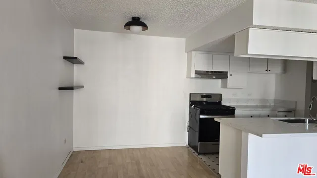 a kitchen with a refrigerator and a stove top oven