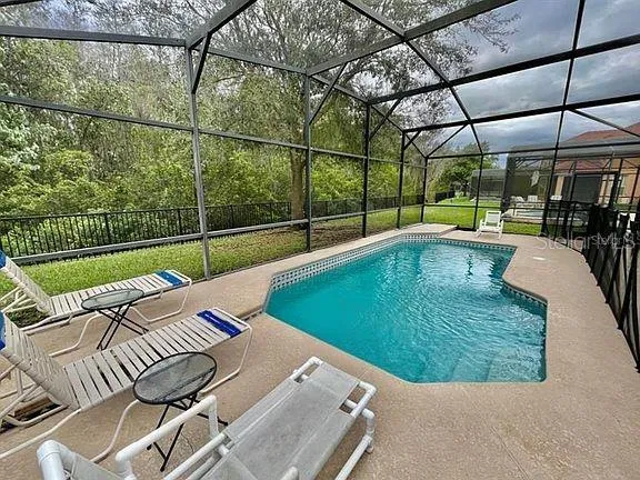 a swimming pool with outdoor seating and yard