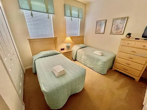 a bedroom with two beds and a window