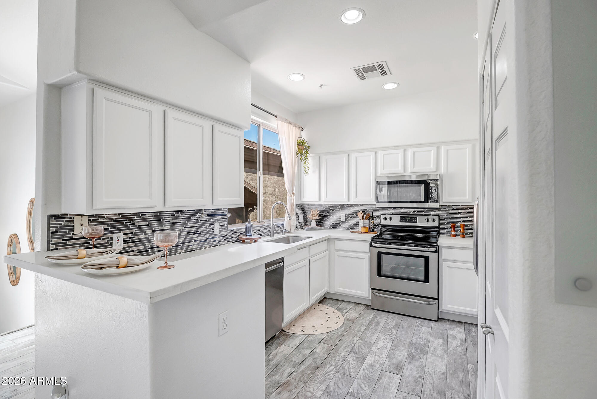 1445 East Broadway Road, Unit 208 Tempe, AZ 85282 - Photo 1 of 29 a kitchen with stainless steel appliances granite countertop a stove top oven a sink and dishwasher a refrigerator with wooden floor