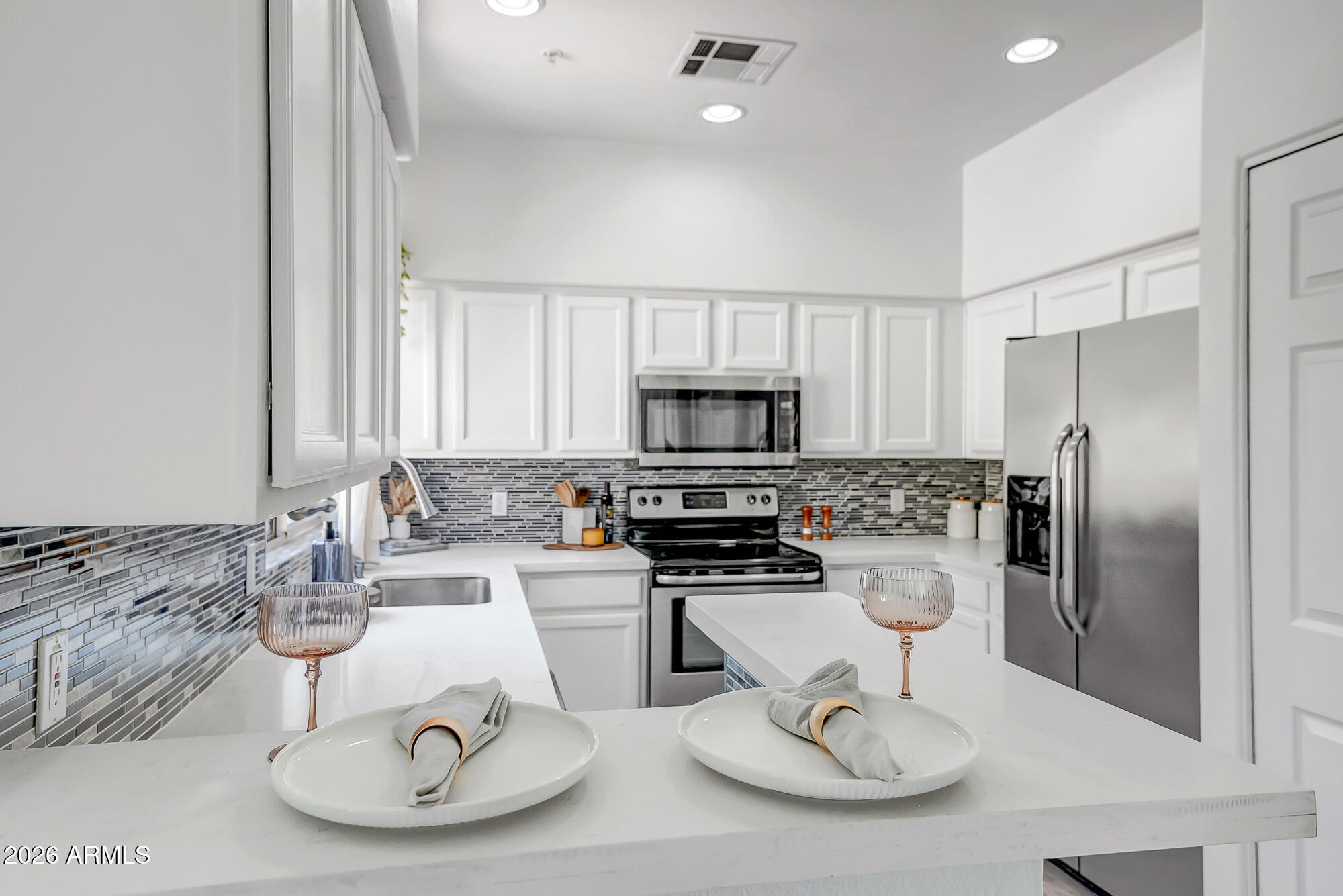 1445 East Broadway Road, Unit 208 Tempe, AZ 85282 - Photo 4 of 29 a kitchen with a sink a stove and chairs