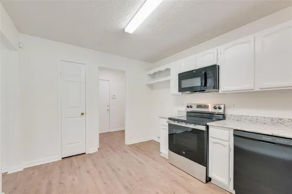 a kitchen with stainless steel appliances granite countertop a stove a sink and a microwave