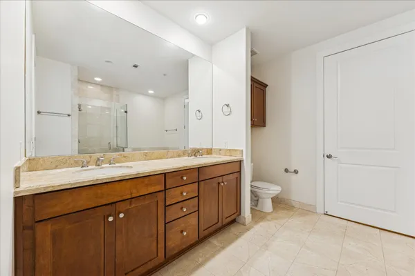 a bathroom with a double vanity sink mirror and toilet