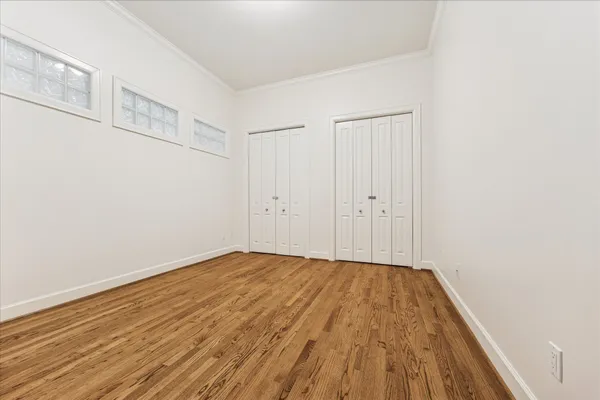 a view of an empty room with wooden floor