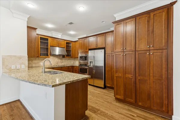 a kitchen with stainless steel appliances granite countertop a sink refrigerator and cabinets