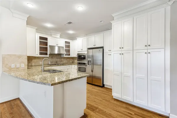 a kitchen with stainless steel appliances granite countertop a refrigerator and a sink