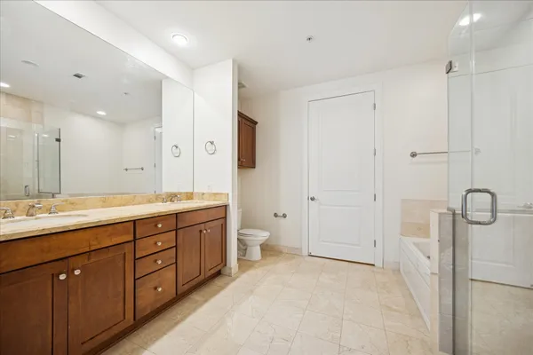 a bathroom with a granite countertop sink a toilet and a shower