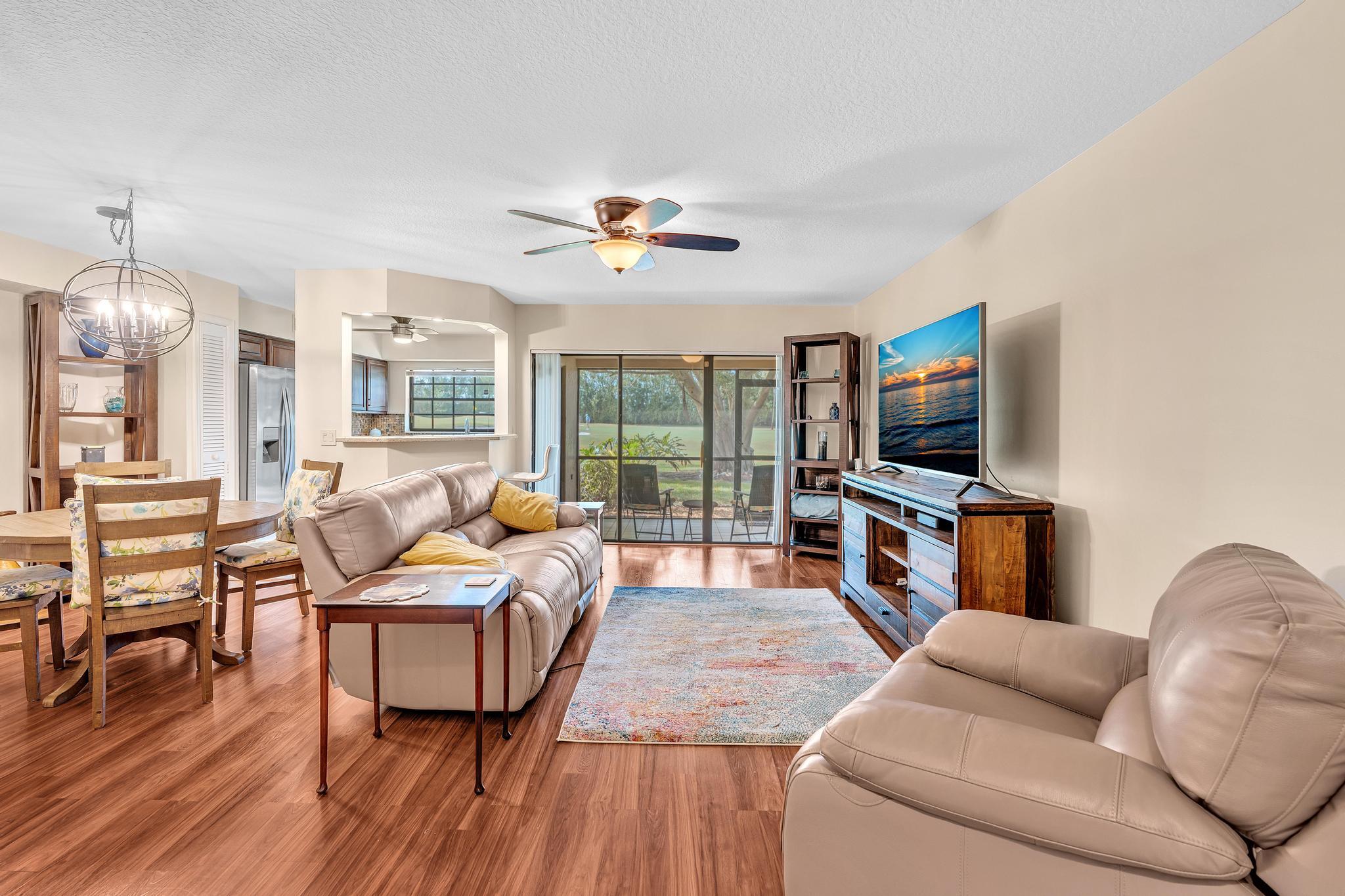 17372 Boca Club Boulevard, Unit 405 Boca Raton, FL 33487 - Photo 12 of 74 a living room with furniture a ceiling fan and a flat screen tv