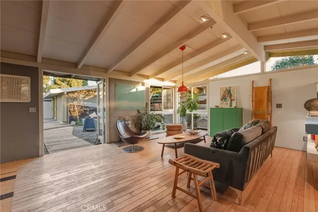 a backyard of a house with table and chairs under an umbrella