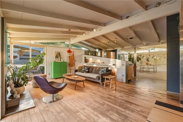 a living room with furniture a wooden floor and next to a window