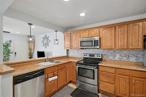 a kitchen with granite countertop a stove sink and microwave