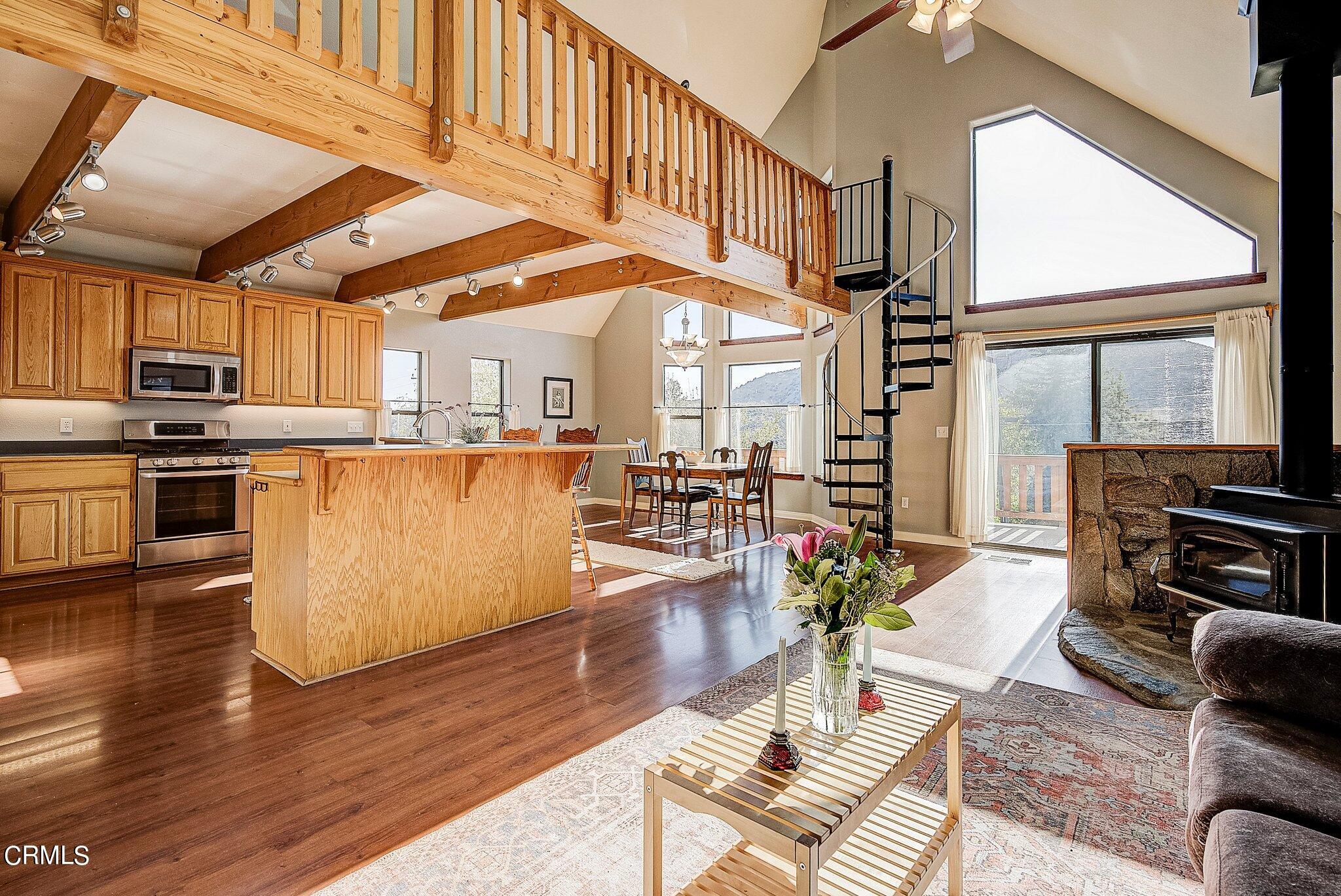5390 Locarno Drive Wrightwood, CA 92397 - Photo 11 of 33 a living room with stainless steel appliances kitchen island granite countertop a stove a refrigerator a couch and a dining table with wooden floor