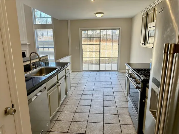 a kitchen with a sink a stove cabinets and a window
