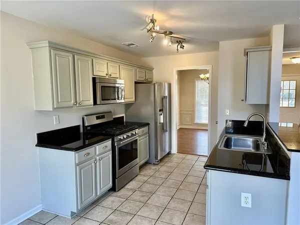 a kitchen with granite countertop a sink and steel appliances