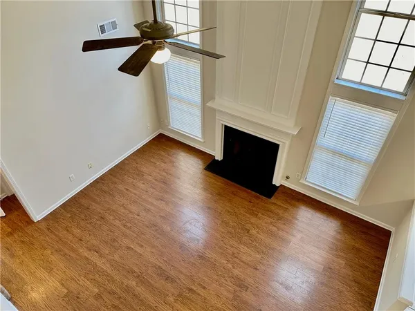 a view of empty room with wooden floor and fireplace