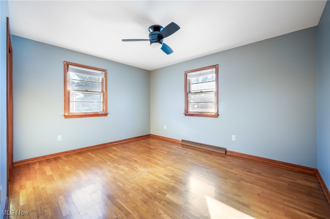 3210 Oser Road Norton, OH 44203 - Photo 35 of 47 Empty room featuring baseboard heating, ceiling fan, and light hardwood / wood-style flooring