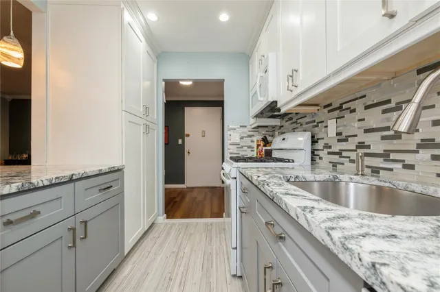 a kitchen with stainless steel appliances granite countertop a lot of counter space and wooden floors