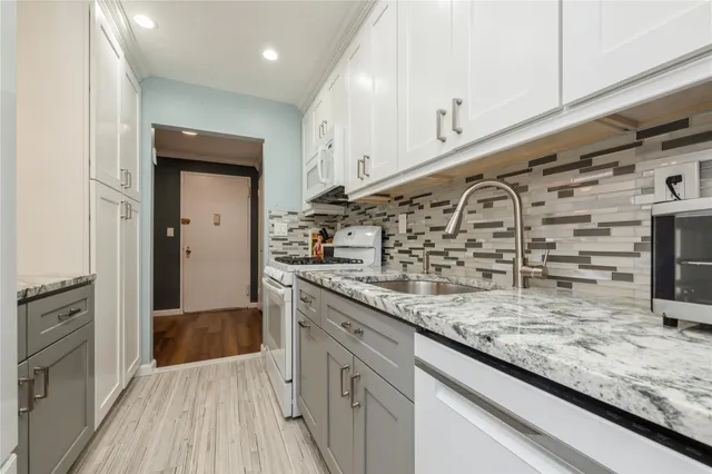 a kitchen with stainless steel appliances granite countertop a sink and wooden floor