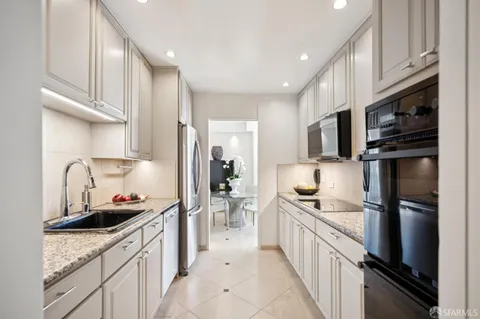 a kitchen with stainless steel appliances a sink stove refrigerator and cabinets