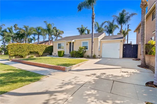 a view of white house with a yard and palm trees