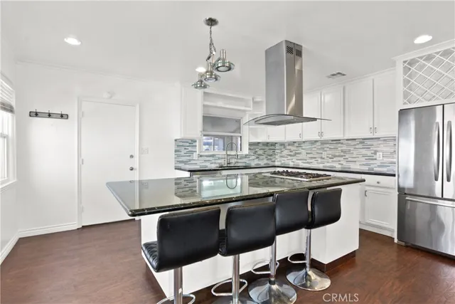 a kitchen with stainless steel appliances granite countertop a sink a stove and a refrigerator