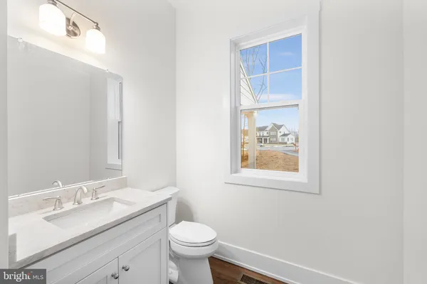 a bathroom with a granite countertop toilet a sink and a mirror