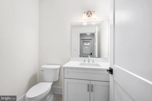 a bathroom with a sink a toilet and mirror
