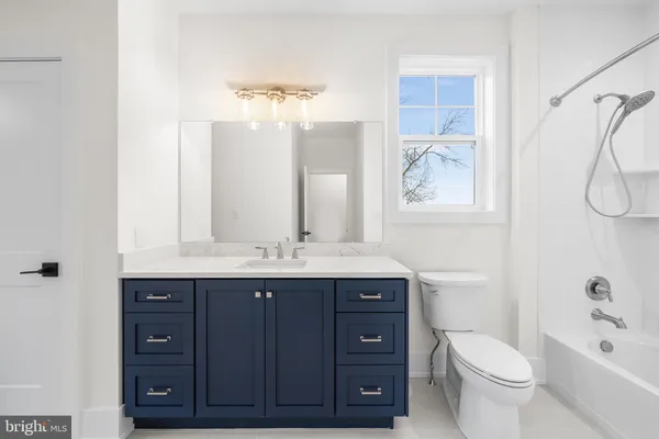 a bathroom with a granite countertop toilet sink and mirror