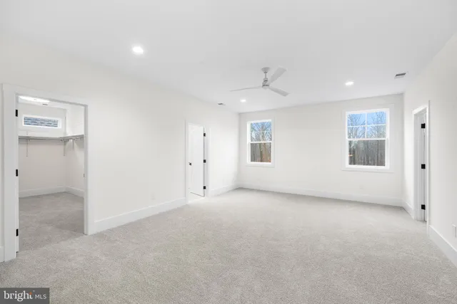 an empty room with windows and closet