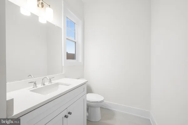 a bathroom with a granite countertop sink a toilet and a mirror