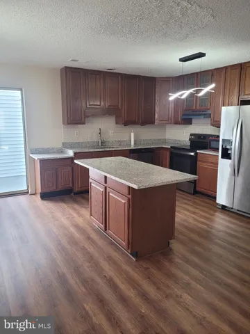 a large kitchen with wooden floors stainless steel appliances