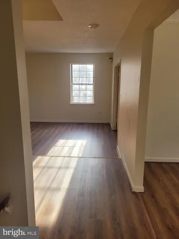a view of a livingroom with wooden floor and a window