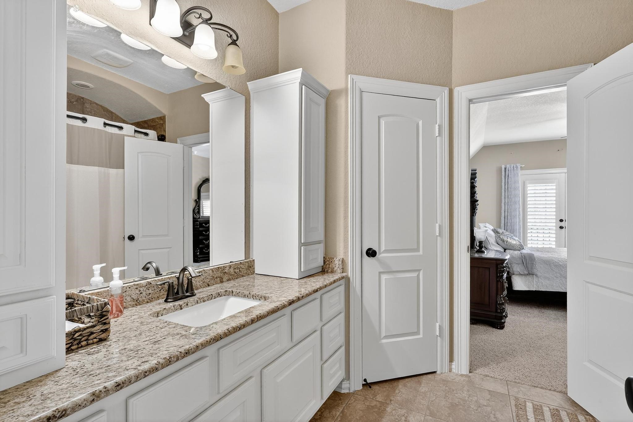 25803 Heritage Maple Drive Spring, TX 77389 - Photo 20 of 46 a en suite bathroom with a granite countertop sink and a mirror