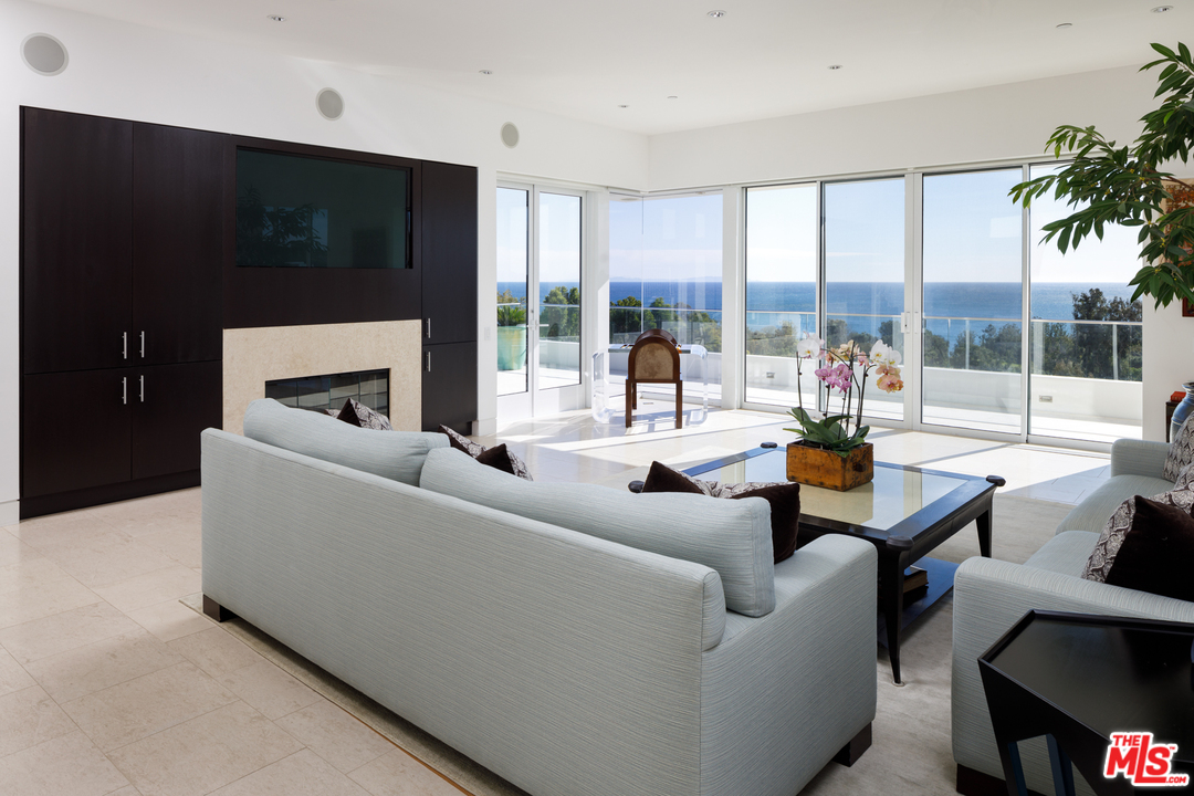 27454 Winding Way Malibu, CA 90265 - Photo 12 of 38 a living room with furniture a flat screen tv and a large window