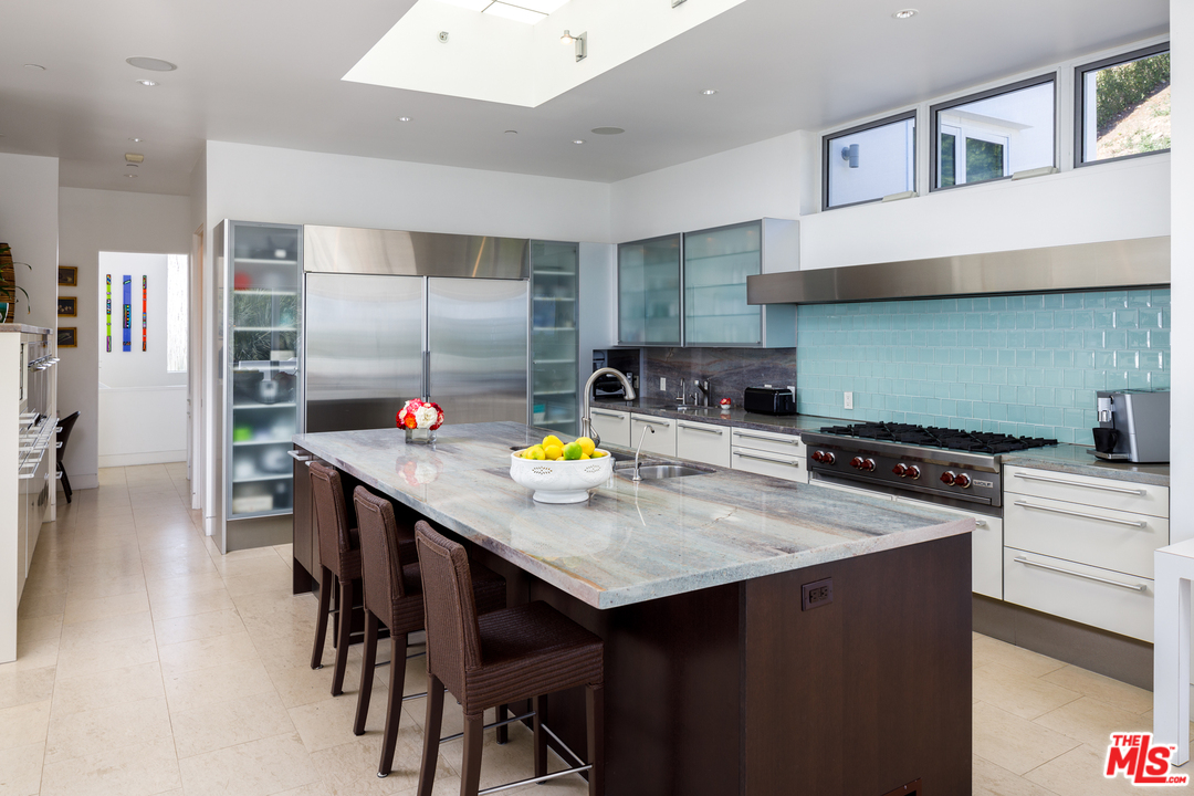 27454 Winding Way Malibu, CA 90265 - Photo 14 of 38 a kitchen with stainless steel appliances a table and chairs in it