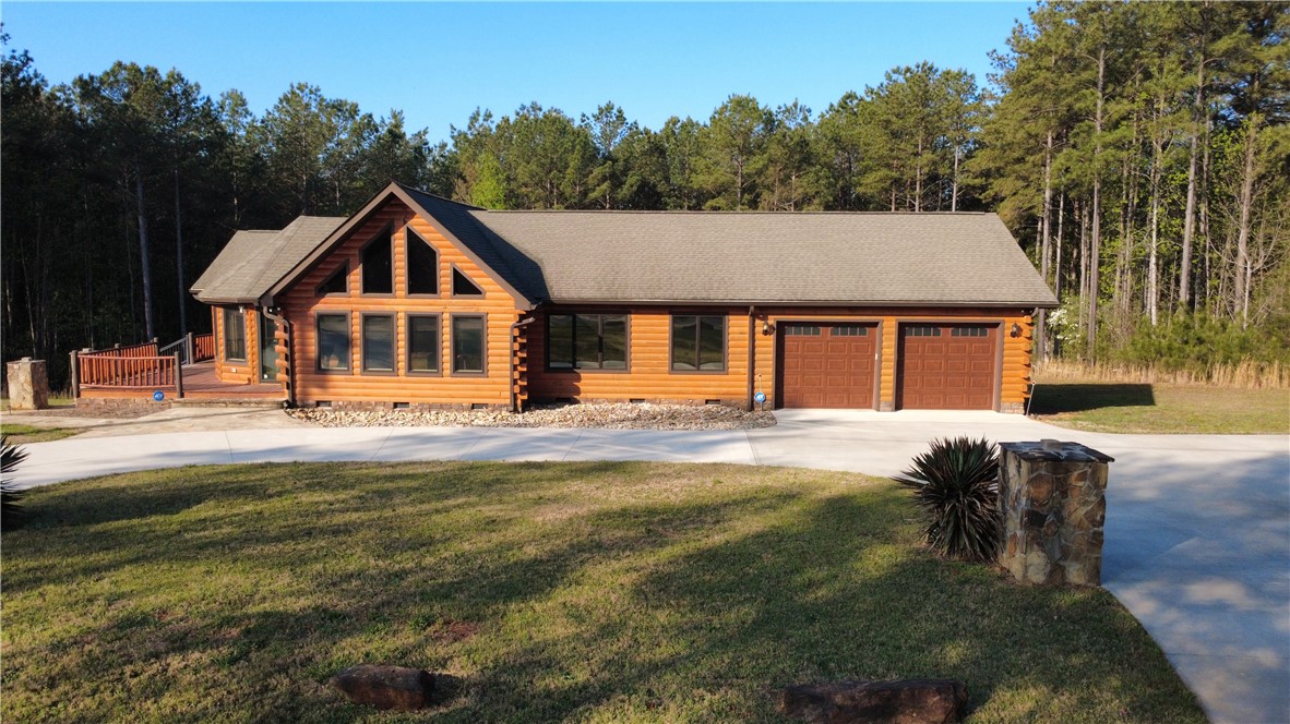 128 McAlister Road West Union, SC 29696 - Photo 35 of 40 A charming log cabin residence, complete with a generous garage and expansive natural surroundings, offers peaceful living.