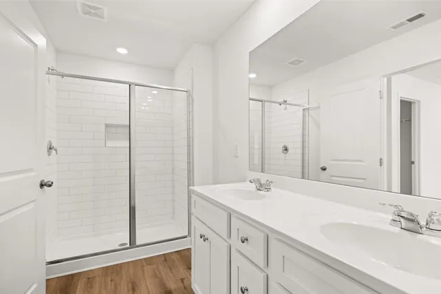 a bathroom with double vanity sink and a mirror