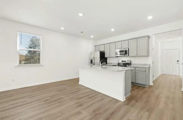 a kitchen with white cabinets and appliances