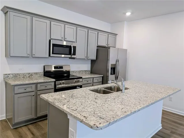 a kitchen with stainless steel appliances granite countertop a sink stove and refrigerator