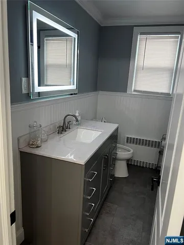 a bathroom with a double vanity sink a toilet and a mirror
