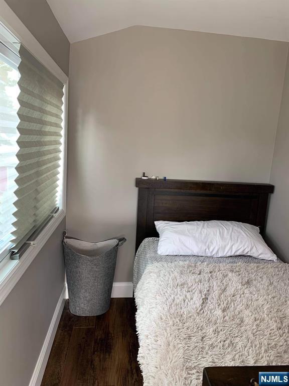 60 Dick Street Clifton, NJ 07013 - Photo 9 of 10 a bed sitting in a bedroom next to a window with wooden floor