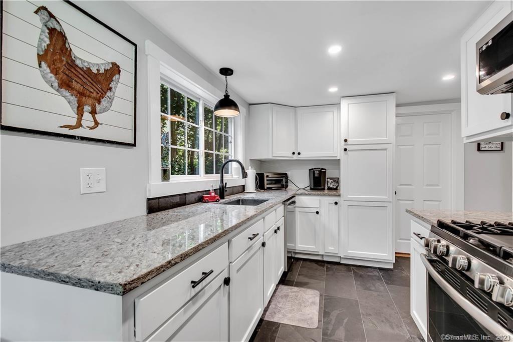 32 Lakeview Drive Bethlehem, CT 06751 - Photo 7 of 12 a kitchen with granite countertop a sink stainless steel appliances and white cabinets